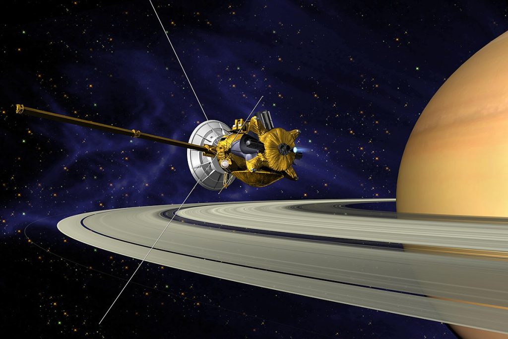 Artist's illustration of the Cassini spacecraft flying above Saturn's rings with the planet visible in the background against a starry sky