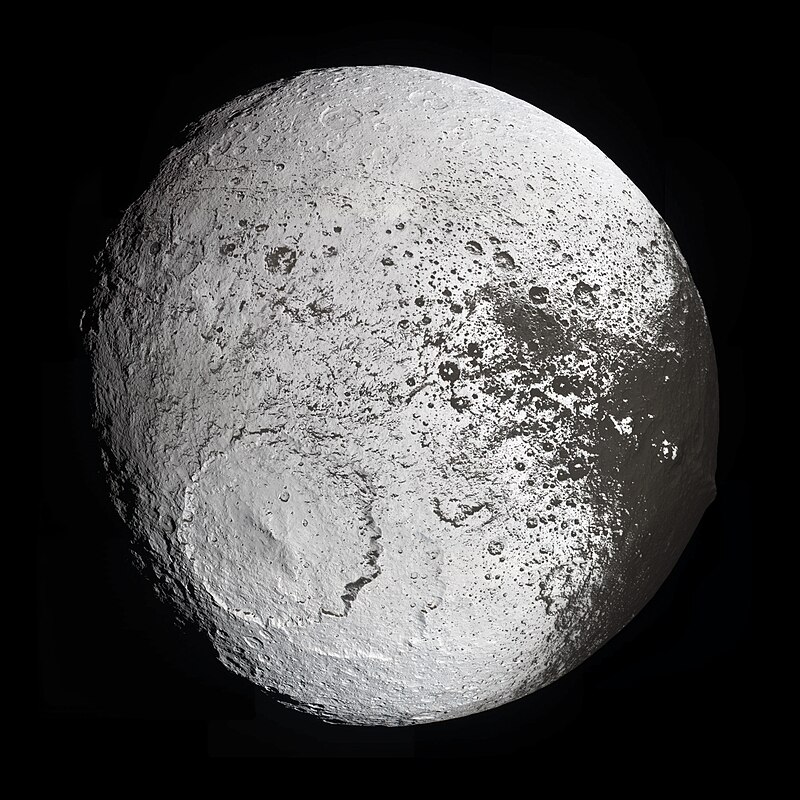 Iapetus, Saturn's third-largest moon, showing its distinctive two-toned surface with a bright icy hemisphere and a dark region covered in organic material.